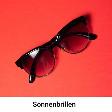 Sonnenbrille auf rotem Hintergrund