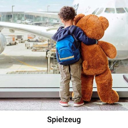 Kind, das mit Teddy im Flughafen steht
