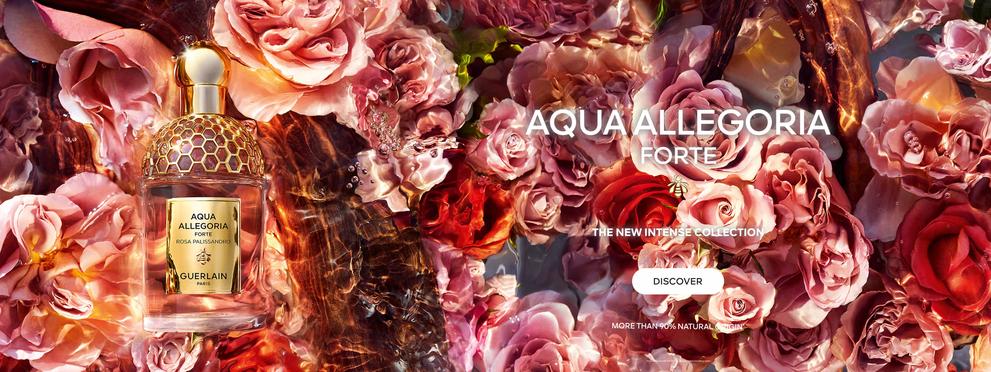 The image is an advertisement for the "Aqua Allegoria Forte" perfume collection by Guerlain, featuring a luxurious bottle amid multicolored roses, highlighting the collection's intensity and natural origin above 90%.