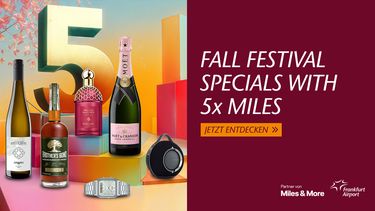 Werbebanner mit buntem Hintergrund. Abgebildet sind Wein, Whisky, Champagner, Uhr und Lautsprecher. Text: 'Fall Festival Specials with 5x Miles'.