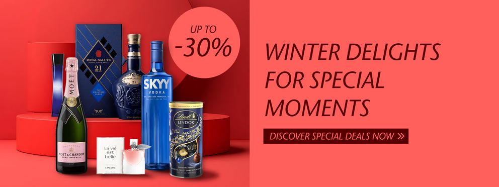 The advertisement showcases a selection of luxury products such as champagne, whisky, perfume, and chocolates, perfect for special winter moments. With discounts of up to 30%, it invites customers to explore the offers.