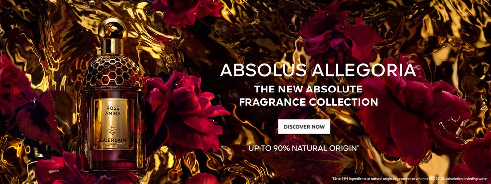 Bottle of Guerlain perfume "Rose Amira" from the Absolus Allegoria collection, surrounded by red rose petals on a golden shimmering background. Text on the image: "Absolus Allegoria - The New Absolute Fragrance Collection. Up to 90% natural origin.