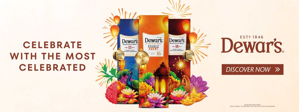 Dewar’s Scotch whisky advertising banner with festive gift boxes, gold medals, and Diwali-themed decorations such as flowers, peacock, and lanterns on a beige background. Text: “Celebrate with the most celebrated.” Dewar’s logo and “Discover now” button.