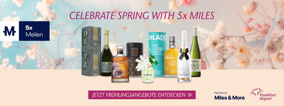 Eine Werbeanzeige für eine Frühlingspromotion, die das Sammeln von fünffachen Meilen bei Miles & More bewirbt, mit einer Auswahl an Produkten wie Champagner und Whisky vor einem blumigen Hintergrund. Der Flughafen Frankfurt wird als Partner erwähnt.